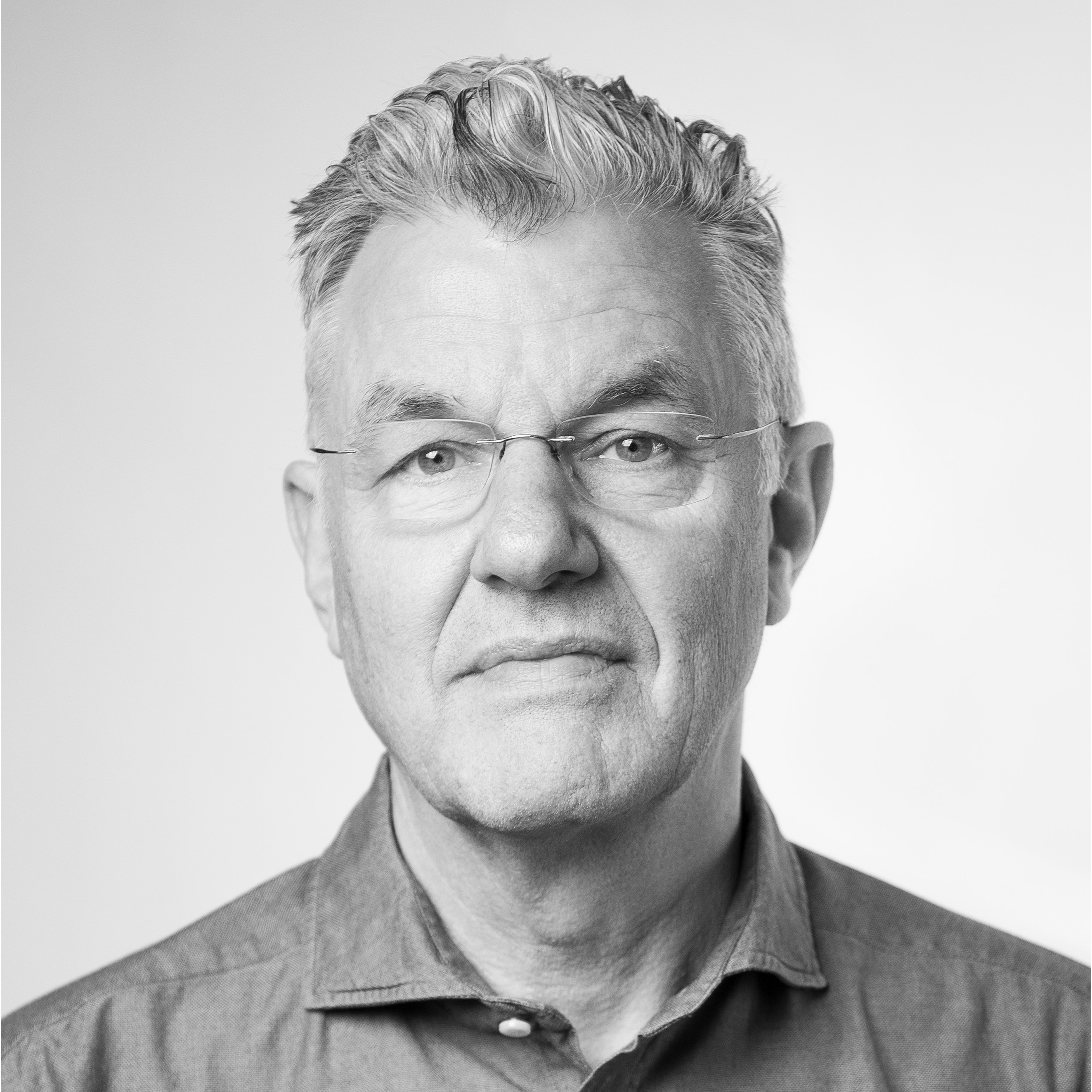 Porträt von Prof. Achim Heine, einem mittelalten Mann mit kurzen grauen Haaren. Bild in Schwarz-Weiß mit grauem Hintergrund.